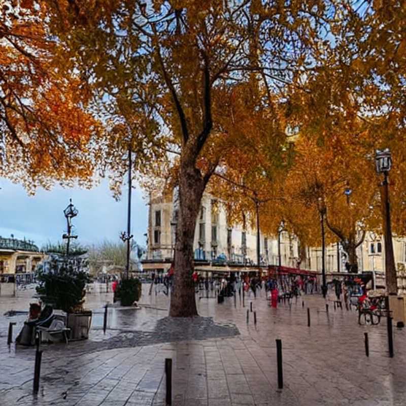 French: Deux amies savourant le soleil printanier sur la Place de la Comédie à Montpellier, une pause parfaite pendant les vacances de printemps.
