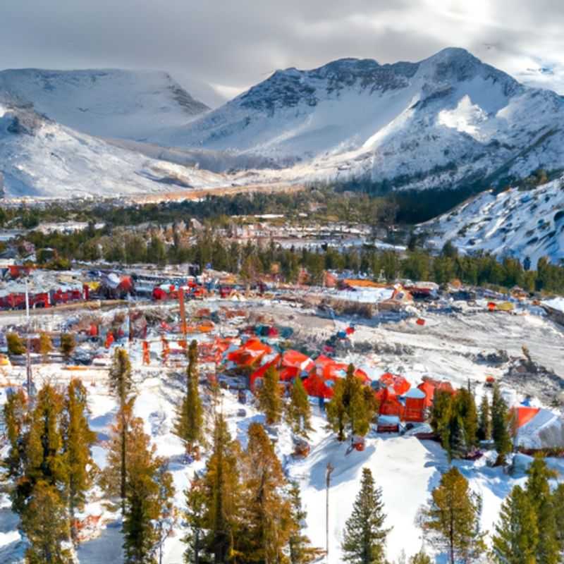 Six skiers bask in the exhilaration of gliding down the pristine slopes of Mammoth Mountain, USA, surrounded by breathtaking snow-capped peaks, during their adventurous 3-week ski vacation.