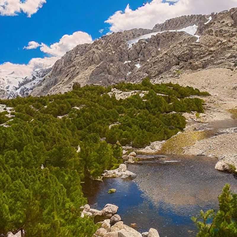 Deux randonneurs admirant les sommets enneigés de la Sierra Nevada, Espagne, sous le soleil printanier, une pause rafraîchissante pendant leur séjour de vacances de printemps.