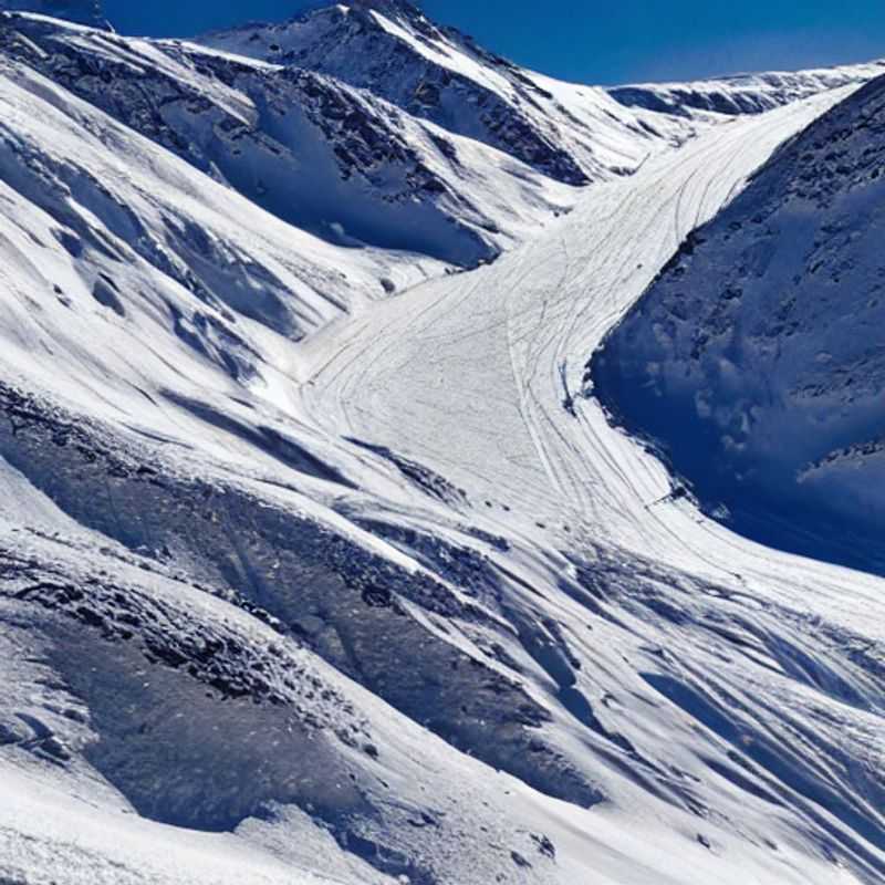 Dois esquiadores descendo as encantadoras pistas nevadas em Obergurgl, Áustria, em uma ensolarada tarde de primavera durante as férias de primavera.