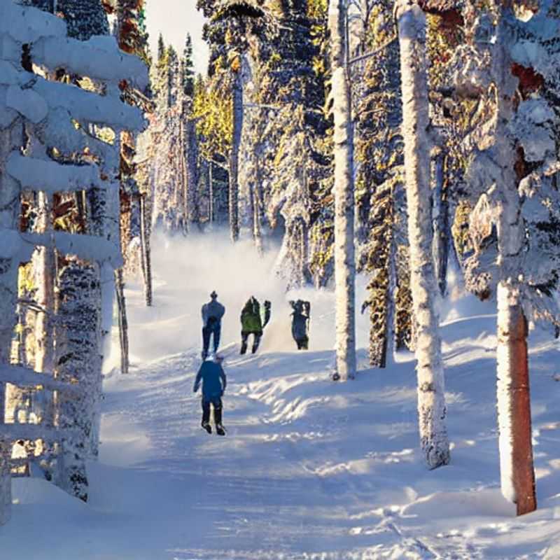 Duas pessoas radiantes, aproveitando o sol da primavera e a neve cintilante de Ruka, Finlândia, durante as férias da primavera - diversão garantida!